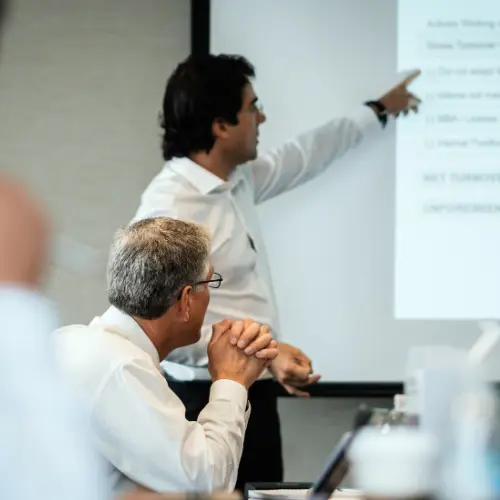 Expert trainer explaining pivot table architecture on a whiteboard during one-on-one coaching.