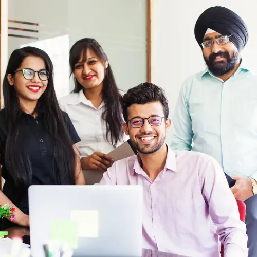 Diverse marketing team reviewing campaign performance metrics together on a laptop.